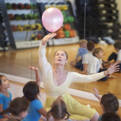 a teacher of ballet pushing a balloon