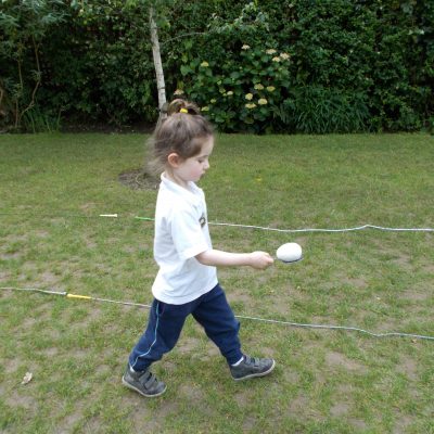 child walking with an egg on a spoon