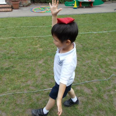 child balancing a bean bag on his head