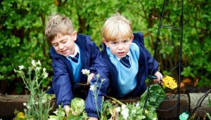 2 young boys with their gardening tools in hand
